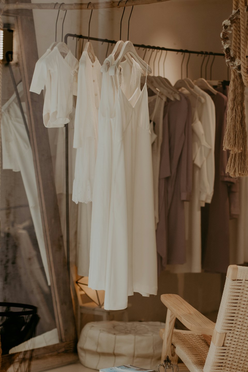 Scaffale di abiti con vestiti chiari in una boutique.